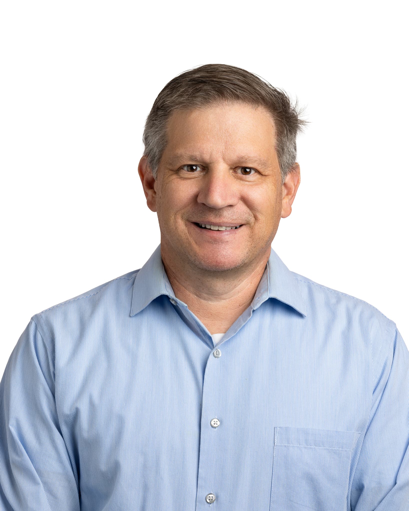 Smiling middle-aged man with short graying hair wearing a light blue pinstriped button-down shirt.